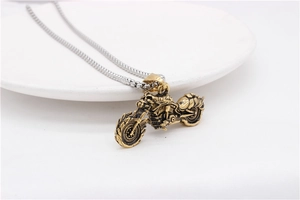 Detail of vintage gold motorcycle pendant with intricate mechanical textures and silver chain