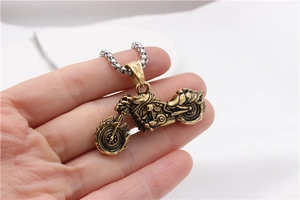 Detailed close-up of a vintage motorcycle pendant with flame texture on a square pearl chain