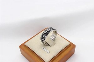 Detail of vintage steel ring featuring embossed running wolf and forest in wild nature style