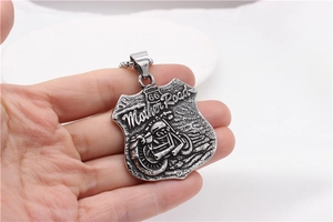 Detail view of large vintage Route 66 motorcycle pendant in hand showing actual scale