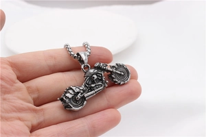 Close-up of vintage silver motorcycle pendant with detailed flame texture and box chain