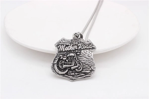 Detail of vintage Route 66 shield pendant with motorcycle relief on steel curb chain