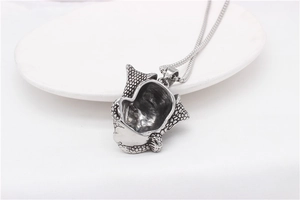 Detailed macro of vintage silver skull pendant with realistic bone texture and steel chain