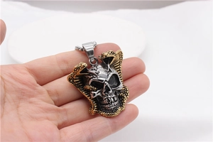 Close-up of retro stainless steel skull pendant with gold snake details and silver finish