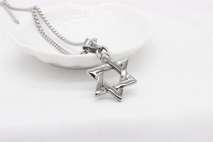 Macro shot of silver polished Star of David pendant on a delicate box chain necklace