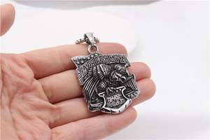 Detailed close-up of retro motorcycle pendant with eagle motif and biker quote