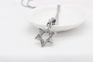 Detailed close-up of a 3D silver Star of David pendant with a vintage box chain texture