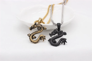 Macro shot of 3D Chinese dragon pendants in gold and black with detailed scale textures