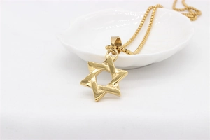 Macro detail of gold plated Star of David pendant necklace with a polished box chain