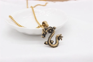 Detailed close-up of a vintage golden dragon pendant with intricate dragon scale textures