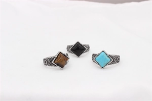 Macro view of vintage stainless steel rings with engraved feathers and gemstone inlays