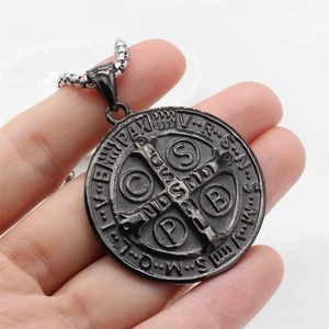 Détail macro d'un pendentif médaille de Saint Benoît gris fusil avec relief métallique précis