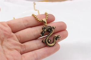 Detailed view of golden 3D dragon pendant with intricate scales on a box chain necklace