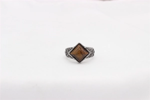 Detail of vintage steel ring featuring embossed textures and a rhombic tiger eye stone