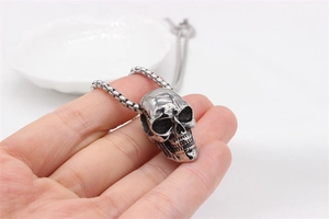 Gros plan d'un collier pendentif tête de mort vintage en acier inoxydable avec chaîne solide