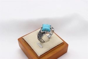 Detail of vintage steel ring with square blue turquoise stone and sunburst carvings