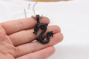 Detailed close-up of a 3D black dragon pendant necklace with intricate scale textures