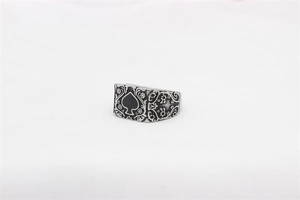 Gros plan d'une bague pique vintage avec des sculptures florales et symbole de l'as de pique