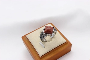 Detail of square red goldstone inset on vintage silver textured stainless steel ring