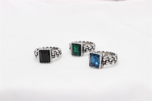 Macro view of vintage style rings featuring emerald cut gems and beaded silver bands