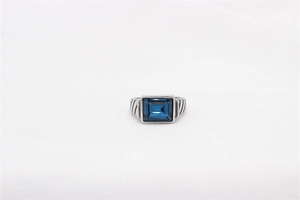 Vista macro de piedra azul rectangular en un anillo con banda de cable trenzado