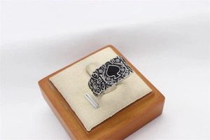 Détail macro de la bague pique vintage en acier avec relief floral et fini argenté