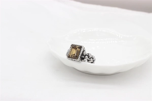 Detailed shot of rectangle amber gemstone set in vintage beaded silver ring band