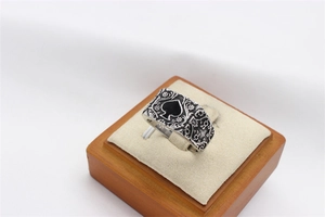 Vue macro d'une bague pique vintage avec gravures florales sur un support en bois