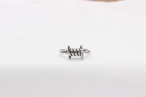 Close-up of vintage industrial thorn wire design on a men's stainless steel ring