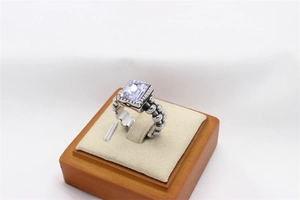 Detail of vintage ring featuring a rectangular purple gemstone and textured silver band