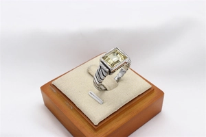 Detalle de anillo retro de acero plateado con gema amarilla y textura de cable trenzado