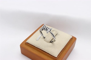 Detailed view of industrial style silver screw thorn ring on beige velvet stand