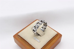 Macro view of vintage Cuban link chain ring with engraved texture on stainless steel