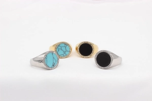Detail of round signet rings with turquoise or black stones and zircon borders