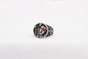 Macro view of vintage knight shield ring with red enamel cross on polished steel