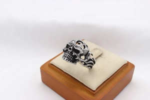 Macro shot of silver skull ring with flame hollow design on display stand