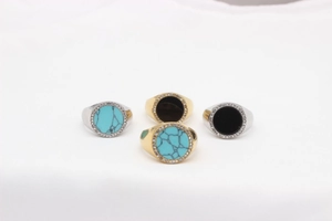 Detail of vintage round titanium steel rings with turquoise, black onyx and zircon accents