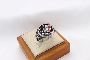 Close-up of retro crusader knight shield ring with red cross relief on a display stand