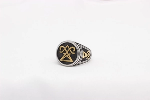 Detail of Viking signet ring featuring golden geometric symbol and embossed side cross