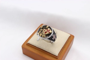 Macro detail of crusader knight signet ring featuring a red cross shield on silver steel