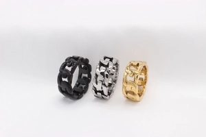 Detailansicht von Panzerketten-Ringen in Schwarz, Silber und Gold mit hohler Struktur