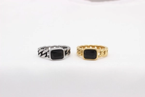 Detail of cuban link chain rings with rectangular black gemstone in gold and silver finish