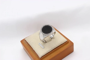 Detailed view of men's round black stone signet ring with micro-pave white crystals