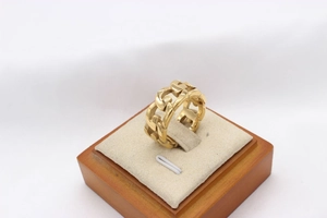 Detailaufnahme eines goldenen Panzerkettenrings aus robustem Edelstahl-Material