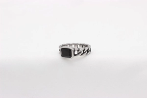 Detailed close-up of a silver chain-link band ring with a rectangular black gemstone inlay