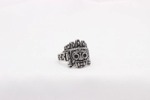 Detailed view of the vintage tribal mask design on a retro stainless steel alien ring
