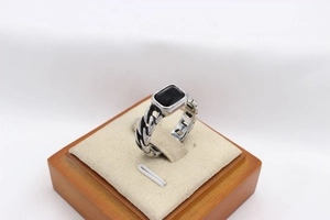 Macro detail of silver chain-link steel ring with rectangular black gemstone inlay
