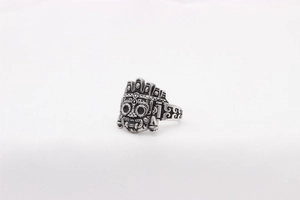 Detailed view of vintage alien mask engraving and wave relief on silver steel ring