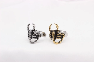 Detailed close-up showing the intricate scorpion design and textured steel finish on gothic rings
