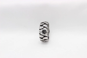 Close-up of vintage steel ring with black oxidized chain texture and woven pattern
